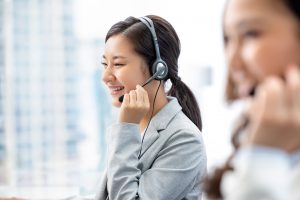 Istock/:Kritchanut Smiling beautiful Asian woman working in call center city office as a customer service operator with team